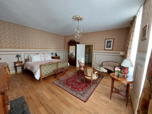 a bedroom with a bed and a table and chairs at La Guériniere in Châteauneuf-sur-Charente