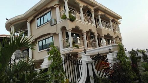 MAYRAH Inn - Your comfortable home from home in Freetown Sierra Leone في Goderich: مبنى كبير عليه بلكونات ونباتات