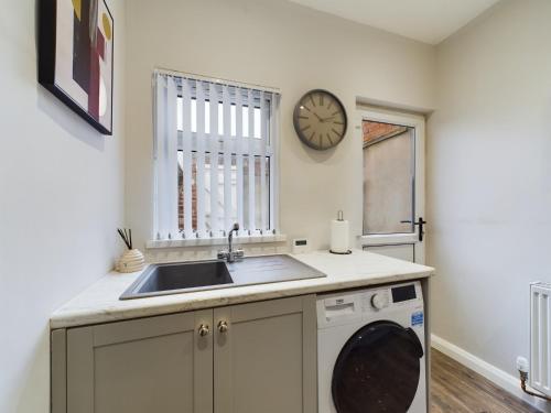 a kitchen with a sink and a washing machine at Mill House, Belfast City Centre in Belfast