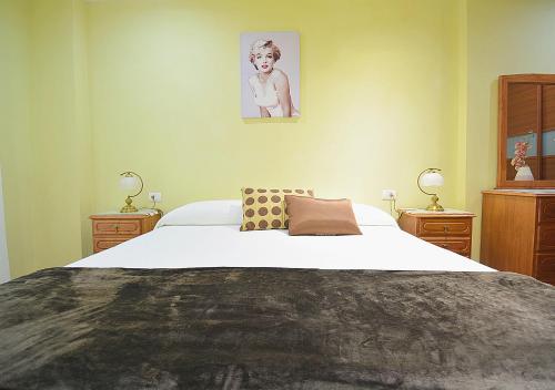 a bedroom with a large bed and two night stands at Apartamento frente al mar en A Illa de Arousa in Isla de Arosa