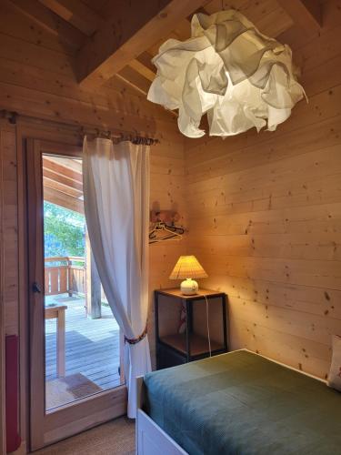 a bedroom with a bed and a chandelier at Chalet Le Sapin in Le Grand-Bornand