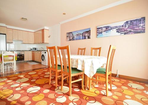a kitchen and dining room with a table and chairs at Apartamento frente al mar en A Illa de Arousa in Isla de Arosa