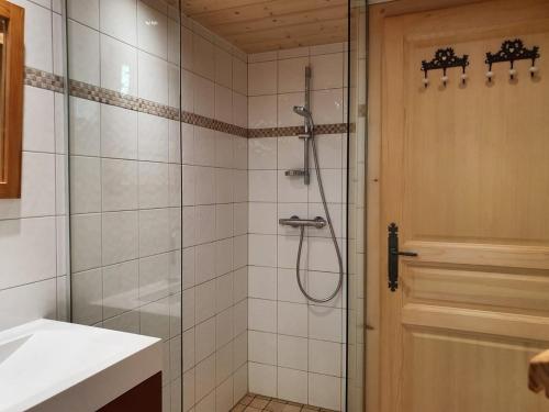 een badkamer met een douche en een glazen deur bij Chalet Le Sapin in Le Grand-Bornand