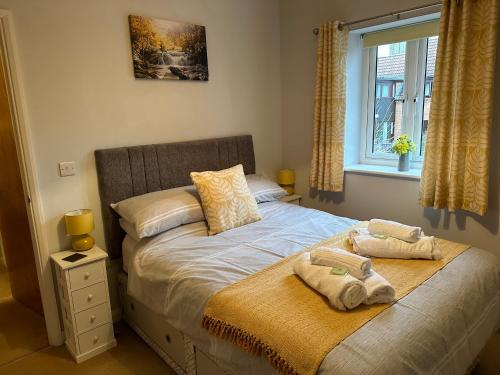 a bedroom with a bed with two towels on it at Abbotsleigh Rest - close to Glastonbury Abbey in Glastonbury