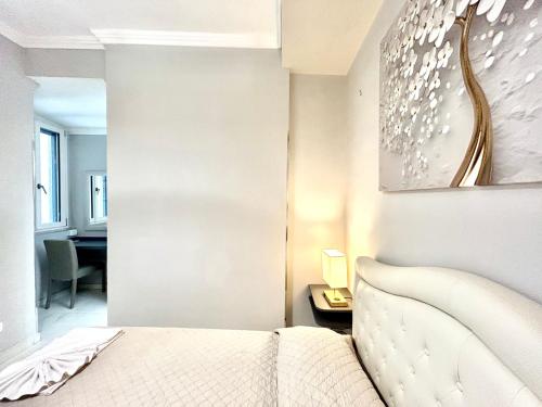 a bedroom with a white bed and a table and a desk at Villa Diana Exclusive Apartment in Taormina