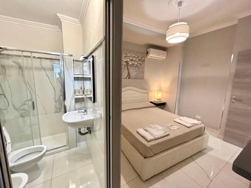 a bedroom with a bed and a shower and a sink at Villa Diana Exclusive Apartment in Taormina