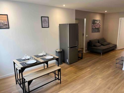 a living room with a table and a refrigerator at Appartement Saint-Etienne hyper centre in Saint-Étienne