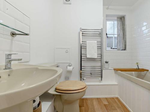 a white bathroom with a toilet and a sink at 1 Bed in Minehead 90923 in Minehead