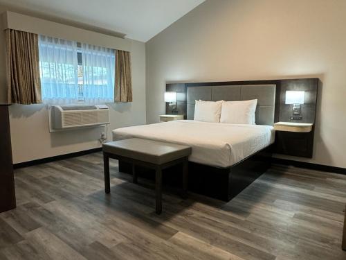 a hotel room with a bed and a window at Days Inn and Suites by Wyndham Port Huron in Port Huron