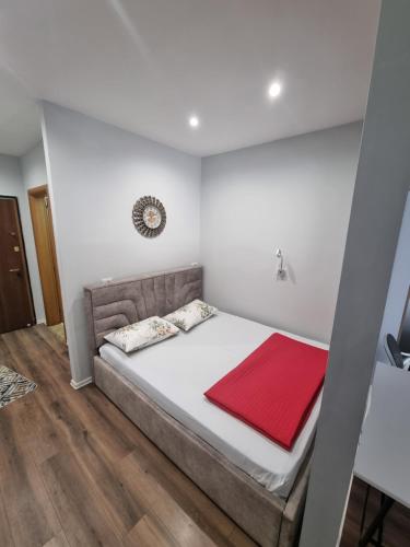 發羅拉的住宿－Alti Prime Seafront Apartments，一间卧室配有一张床铺,床上铺有红色毯子