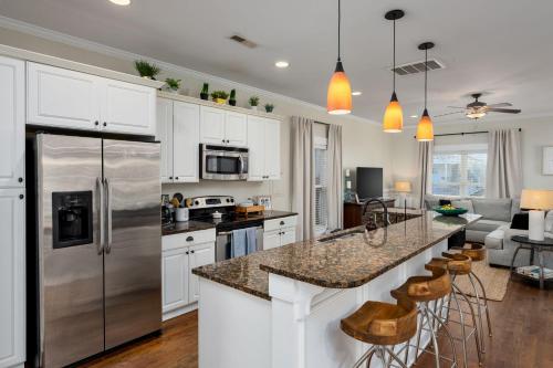 a kitchen with white cabinets and a stainless steel refrigerator at Downtown Wilmington Home ~ Pet Friendly in Wilmington