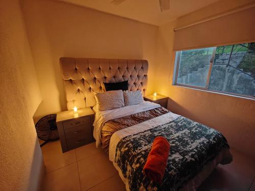 - une chambre avec un lit et une fenêtre avec deux bougies dans l'établissement Paraiso Teques, Casa entera con acceso al lago, à Tequesquitengo