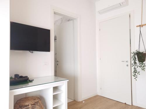 a white living room with a tv on a wall at Casa di Kaixin in Mestre