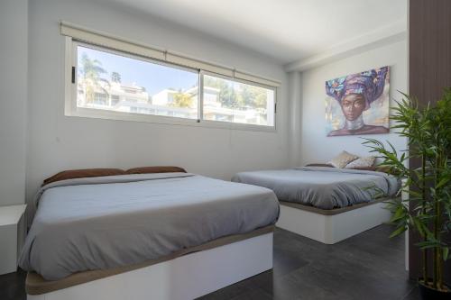 a bedroom with two beds and a window at Villa Oasis Chiva - Tu Lujoso Refugio con Piscina privada in Chiva