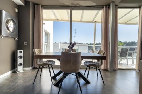 a dining room with a table and chairs and a large window at Descubre Villa Oasis - Confort, diseño y naturaleza a un paso de Valencia in Chiva