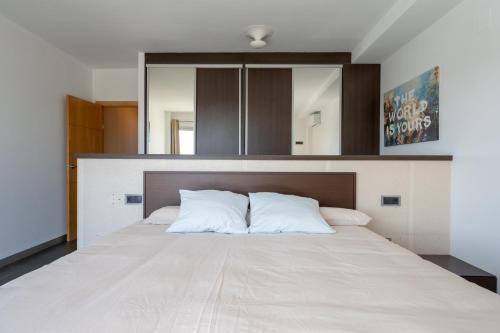 a bedroom with a large bed with white sheets at Descubre Villa Oasis - Confort, diseño y naturaleza a un paso de Valencia in Chiva
