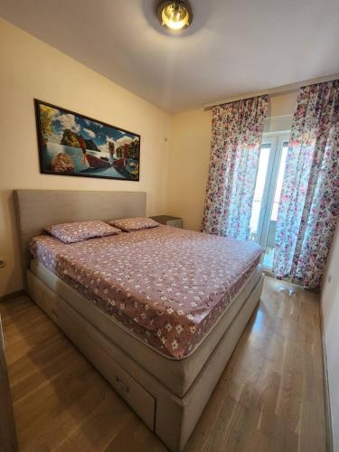 um quarto com uma cama e duas janelas com cortinas em Beko City em Podgorica