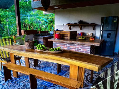 una cocina con una mesa de madera con plátanos. en Cabaña Compartida en Calabazo - Celestial Villa Tayrona, en Santa Marta