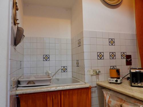 eine Küche mit einem Waschbecken und einer gefliesten Wand in der Unterkunft B&B Maria Piddu in Palermo