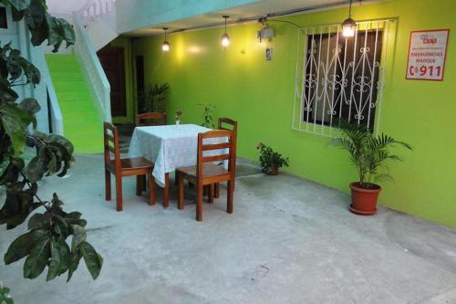 uma mesa e cadeiras num quarto com uma parede verde em Casa de Huespedes Milena em Puerto Baquerizo Moreno
