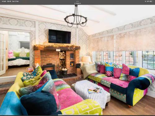 a living room with two couches and a fireplace at Piglet Cottage in Pebworth