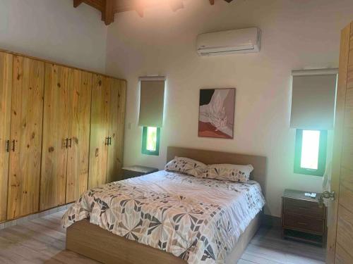 una camera da letto con un letto grande con armadi in legno di Villa María Victoria, en Jarabacoa a Jarabacoa