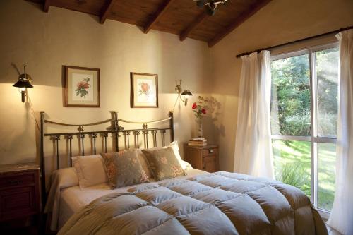 a bedroom with a large bed and a window at La Caledonia Cabañas Boutique in Sierra de la Ventana
