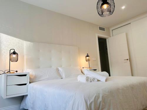 ein weißes Schlafzimmer mit einem großen Bett mit weißer Bettwäsche in der Unterkunft Gran Capitán Home in Córdoba