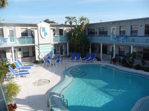 uma piscina em frente a um hotel com cadeiras e um edifício em Royal North Beach em Clearwater Beach