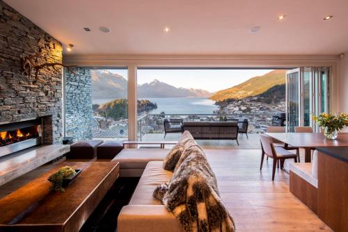 a living room with a couch and a fireplace at Villa Antrim- Lake Views- Gas Fire- Hot Tub in Queenstown