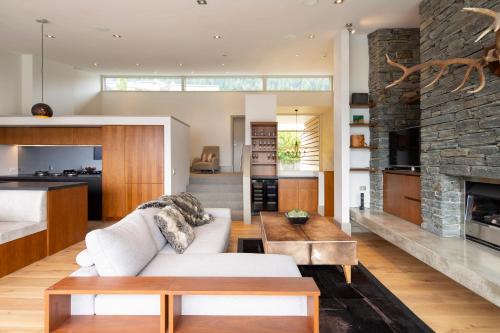 a living room with a couch and a fireplace at Villa Antrim- Lake Views- Gas Fire- Hot Tub in Queenstown