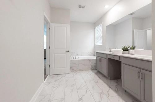 La salle de bains blanche est pourvue d'une baignoire et d'un lavabo. dans l'établissement Top Villas - Championsgate 2186, à Kissimmee
