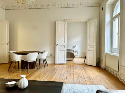 a living room with a table and white chairs at Lägenhet i centrala Stockholm in Stockholm