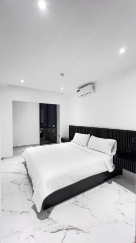 een witte slaapkamer met een groot bed en marmeren vloeren bij MantaSurf Hotel in Tarqui
