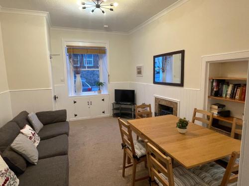 a living room with a couch and a dining room table at 4 bedroom townhouse Kirkcudbright in Kirkcudbright