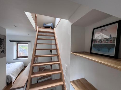 Una escalera que conduce a una habitación con cama en L’Aragne en Dinant