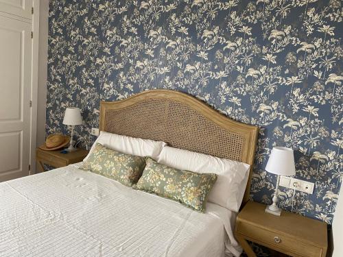 a bedroom with a bed with a floral wallpaper at Luxury Hacienda Golf Islantilla in Islantilla