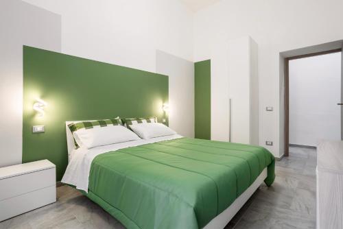 una camera verde con un grande letto con cuscini bianchi di Case Billeci Casa Verde a Palermo