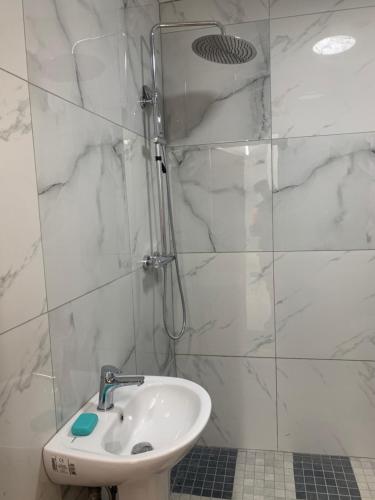 biała łazienka z umywalką i prysznicem w obiekcie Goodmayes Park Home w mieście Goodmayes