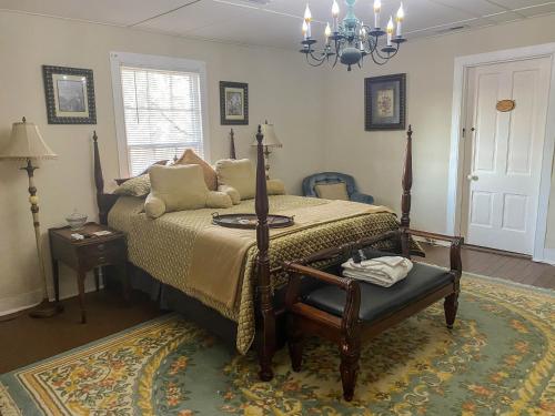 - une chambre avec un lit et un lustre dans l'établissement Vaiden Inn, à Cumberland Landing