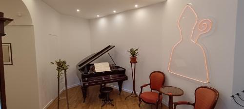 a room with a piano and some chairs at Deluxe Spaccanapoli in Naples