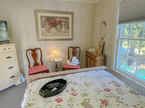 a bedroom with a bed and two chairs at Vaiden Inn in Cumberland Landing