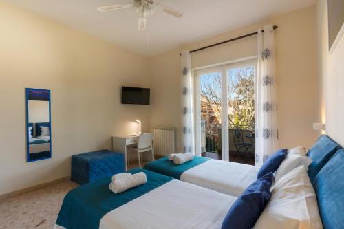 a bedroom with two beds and a window at L'Arancio house- Perfect for families and groups in Sorrento