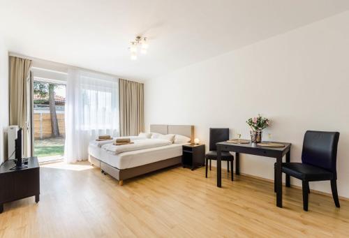 a living room with a bed and a table and a desk at Pension Zličín in Prague