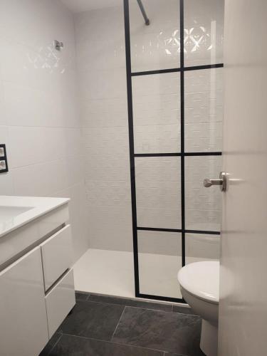 a white bathroom with a toilet and a shower at Des Artistes Son Parc in Son Parc