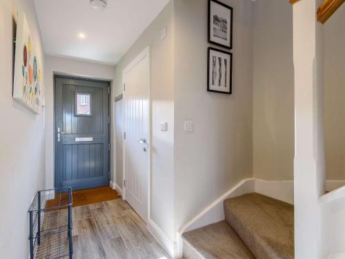 a hallway with a blue door and stairs at 3 Bed in Marston Montgomery 87450 in Marston Montgomery