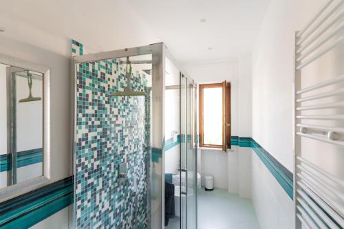 a bathroom with a shower with blue and white tiles at L'Arancio house- Perfect for families and groups in Sorrento