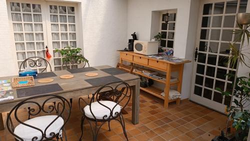 Mortagne-sur-SèvreにあるMaison d'hôtes Les Beaux Chenesのテーブル、椅子、デスクが備わる客室です。