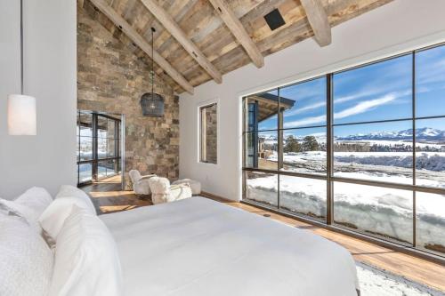 a bedroom with a large white bed and large windows at Silverpick Ranch - adventure & luxury in Telluride in Telluride