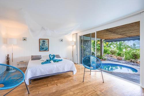 1 dormitorio con cama y piscina en Villas ti creole, en Sainte-Rose